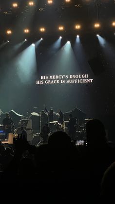 the stage is lit up with spotlights and people are standing in front of it