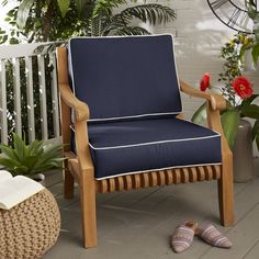 a blue chair sitting on top of a wooden floor next to a potted plant