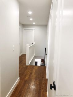 an empty room with hard wood floors and white walls