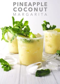 two glasses filled with lemonade and mint garnish on top of a white table