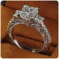 an engagement ring with three princess cut diamonds