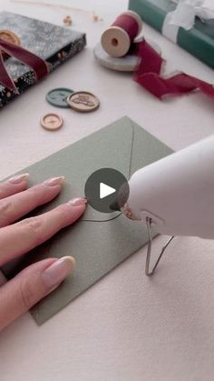 a person using a sewing machine to sew buttons on a piece of paper with scissors