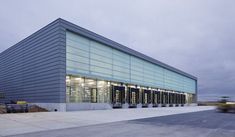 an empty parking lot in front of a large building with many windows and lights on it