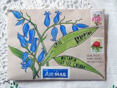 an airmail envelope with blue flowers on it