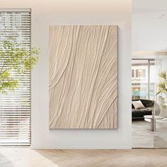 a living room with white walls and wood flooring on the wall, along with a plant