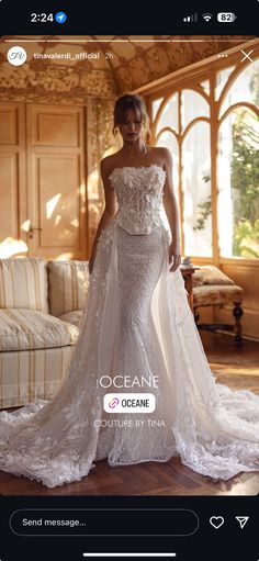 a woman in a white wedding dress standing on a wooden floor next to a couch