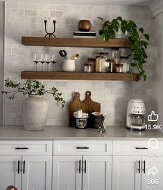 a kitchen with white cabinets and wooden shelves