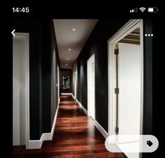 a long hallway with black walls and white trim