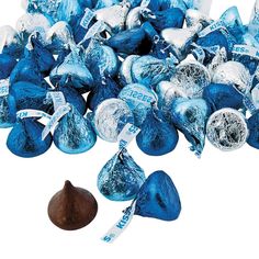 a pile of blue and white chocolate candies next to a piece of candy cane