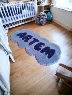 a baby's room with a blue rug that says mama on the floor next to a crib