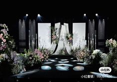 an image of a stage set with flowers and lights in the dark night scene for a fashion show