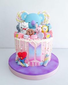 there is a cake decorated with animals and balloons on top of the cake, as well as other decorations