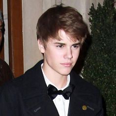 a young man wearing a black jacket and bow tie