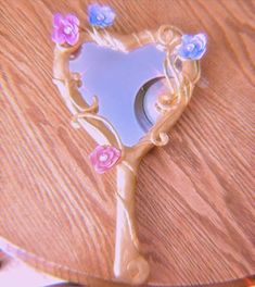 a heart shaped mirror sitting on top of a wooden table