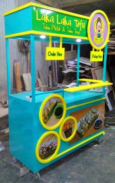 a blue and yellow food cart sitting inside of a building