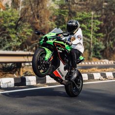 a man riding on the back of a green motorcycle