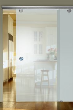 the sliding glass door is open to reveal a dining room with wooden floors and white walls