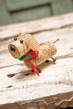 a small wooden toy dog with a red and green scarf on it's neck