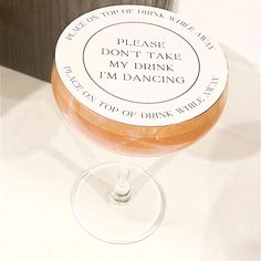 a wine glass with a label on it sitting on a counter top next to a wall