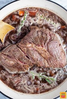 a pot filled with meat and vegetables on top of a table