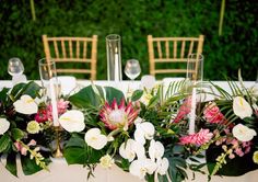 flowers and greenery are arranged on the table for an elegant wedding centerpieces