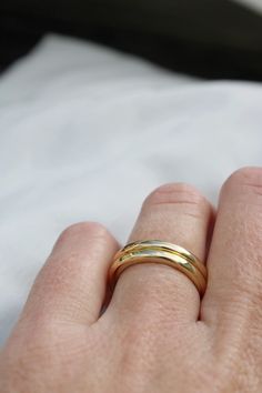 a person's hand with a gold ring on it