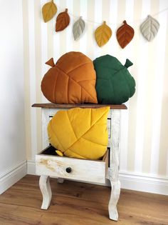 three colorful pillows sitting on top of a white table