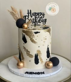 a birthday cake with gold and black decorations