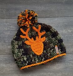 a crocheted hat with an orange and black deer on it