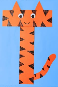 a paper cut out of a cat with eyes and tail, on a blue background