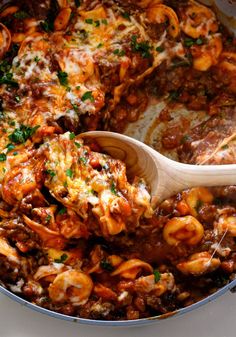 a pot filled with pasta and meat covered in sauce