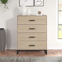 an empty room with a dresser, vases and pictures on the wall above it