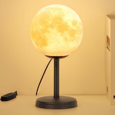 the moon lamp is on top of a table