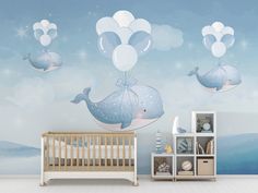 a baby's room decorated in blue and white with balloons floating above the whale