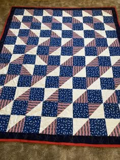 a blue and white quilt is laying on the floor