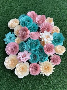 a bunch of paper flowers sitting on top of green grass