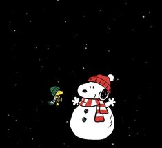 a snowman with a red hat and scarf standing next to a person in the dark