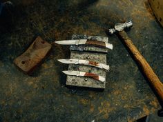 several knives are sitting on top of an old table