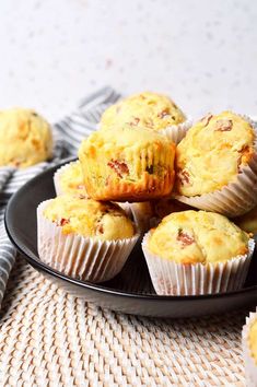 several muffins on a black plate with white and gray napkin next to them