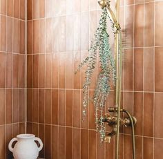 a white vase sitting next to a shower head