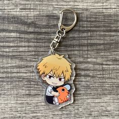 a keychain with an anime character holding a fish on it's back