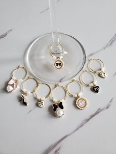 a wine glass filled with lots of different types of earrings on top of a table