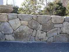 a large stone wall next to a street