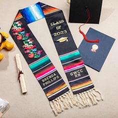 two graduation stoles with the words class of 2013 on them next to a teddy bear