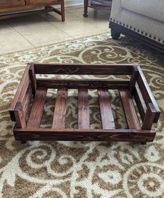 a wooden bed frame sitting on top of a carpeted floor next to a couch