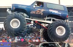 a monster truck is in the air with people watching