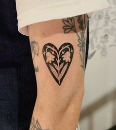 a woman's arm with a heart shaped flower tattoo on the left side of her leg