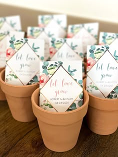 small potted plants with place cards in them