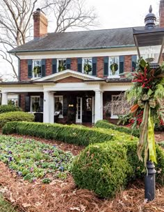 the front yard of a house decorated for christmas with wreaths and flowers on it