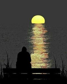 a person sitting on a bench in front of the ocean at night with the sun setting